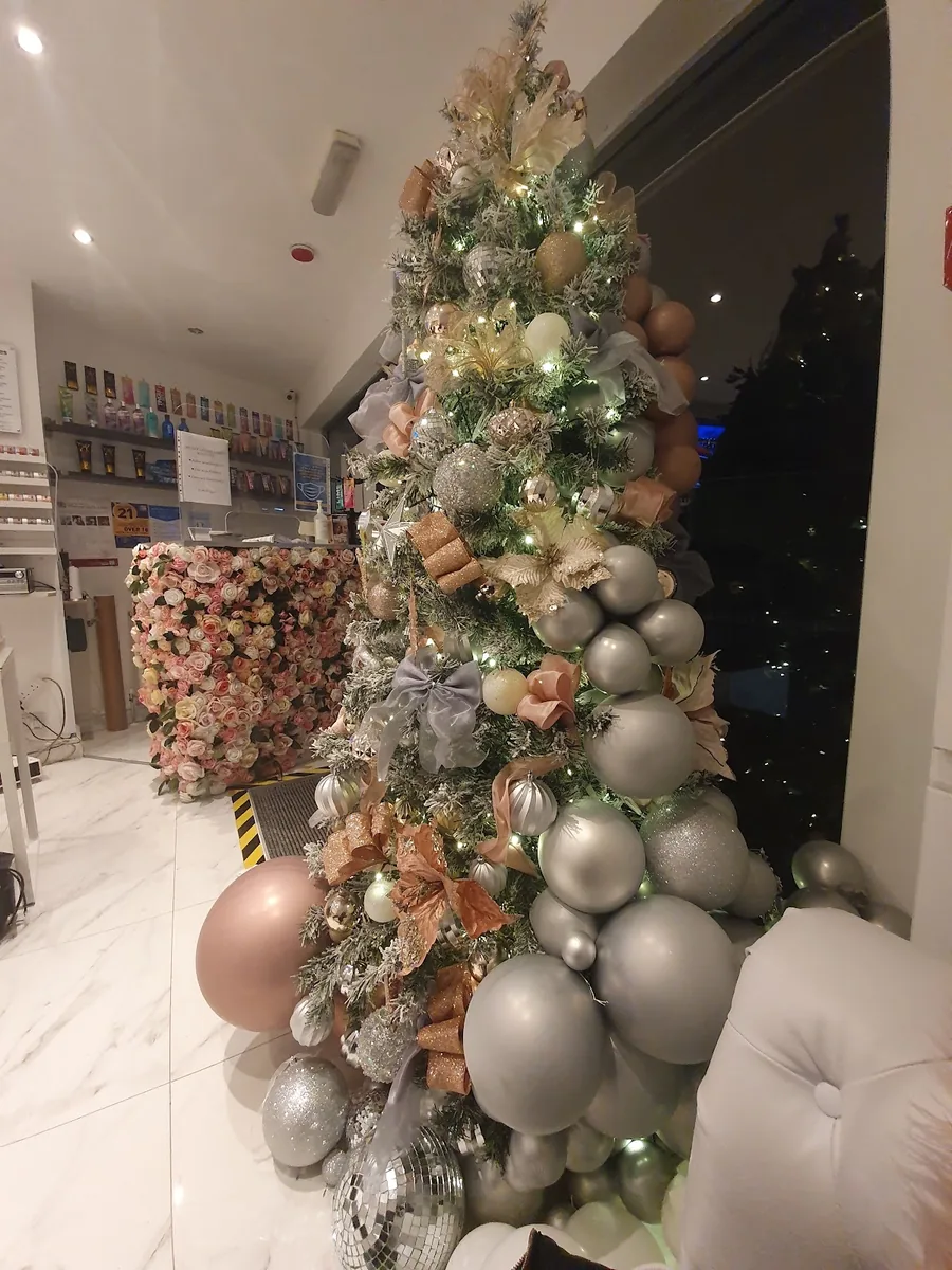 A tall champagne and rose-gold decorated tree standing inside the salon